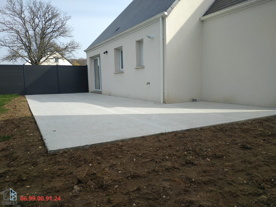Photo du dallage terminée et sec d'une terrasse en L sur l'arrière d'une maison